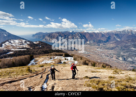 Hikers during the ascent to Monte Stivo Mountain above St. Barbara on Lake Garda, Lake Garda with the village of Riva at the Stock Photo