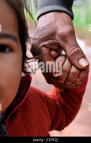 Little girl holding her father's hand, Comunidad Arroyito, Departamento Concepcion, Paraguay, South America Stock Photo