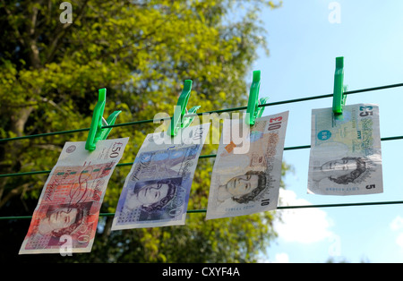 UK bank notes hanging on a washing line. Stock Photo