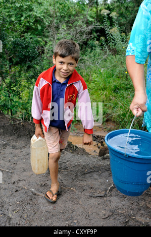 Mother and son fetching water from a stream, Comunidad Martillo, Caaguazu, Paraguay, South America Stock Photo