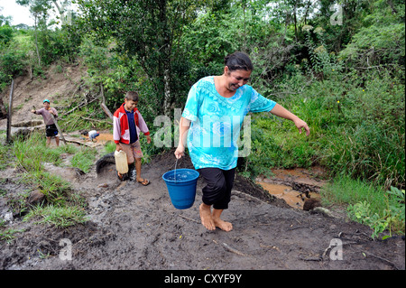 Mother and son fetching water from a stream, Comunidad Martillo, Caaguazu, Paraguay, South America Stock Photo