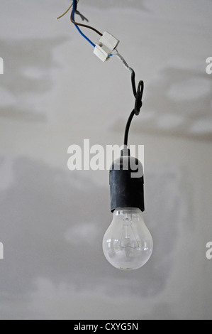 Single light bulb hanging from a ceiling, building renovation Stock Photo