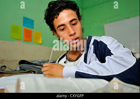 Teenager, 18 years old, doing his homework, he is a former hired killer and member of a gang of youths, Mara, thanks to El Stock Photo