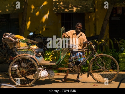 Cycle Rickshaw Driver Posing In Front Of Bunches Of Bananas In A Street Of Pondicherry, India Stock Photo