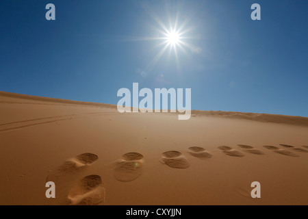 Footprints in the sand and the sun at Coral Pink Sand Dunes State Park, Utah, USA Stock Photo