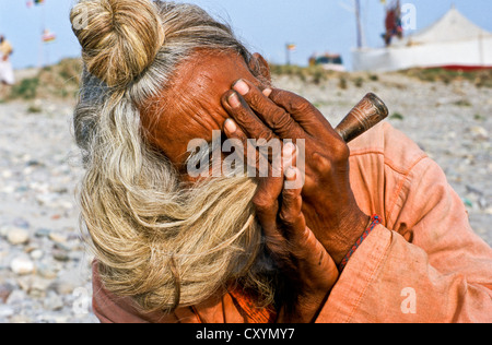 Sadhu, holy man, smoking marihuana during Kumbh Mela or Kumbha Mela, Haridwar, India, Asia