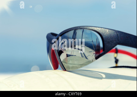A sailing yacht is reflected in a pair of sunglasses Stock Photo