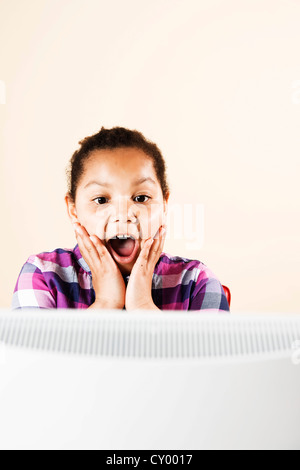 Girl looking surprised at a monitor Stock Photo