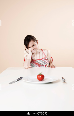 Girl turns away in disgust from a tomato Stock Photo