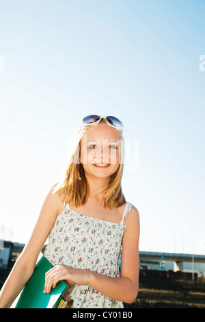 Girl wearing sunglasses carrying a folder Stock Photo