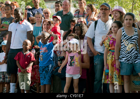 Mixed race group of people of mixed generations watching street entertainers Stock Photo