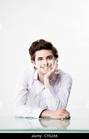 Young man sitting at his desk Stock Photo