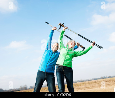 Senior couple doing exercises with walking sticks in a field Stock Photo