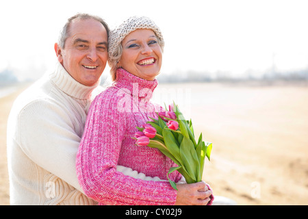 Senior couple holding tulips in their hands Stock Photo