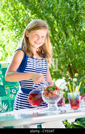 Girl standing at a garden table Stock Photo