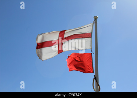 English flag of St George and red danger flag (no swimming) flying on the beach at Goring-by-sea, West Sussex, England UK Stock Photo