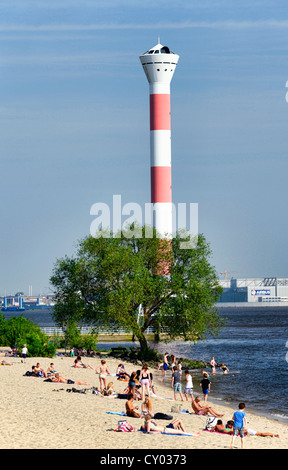 Lighthouse and people lying on the beach on the banks of the Elbe river, Blankenese district, Hamburg Stock Photo