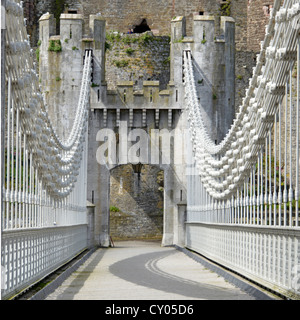 Thomas Telford original Conwy road suspension bridge above the River Conwy now a footpath for pedestrians only Conwy Castle beyond North Wales UK Stock Photo