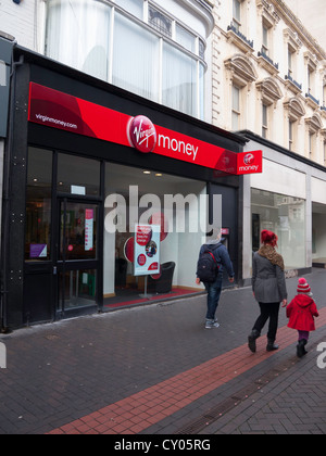 A branch of Virgin Money bank, formerly Northern Rock, in Middlesbrough Cleveland UK with a couple and child walking past Stock Photo