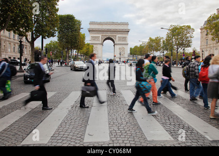 people crossing the l’avenue des Champs-Élysées in front of the Arc de Triomphe in Paris Stock Photo