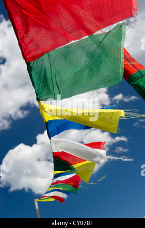 Tibetan prayer flags against a blue sky with clouds Stock Photo