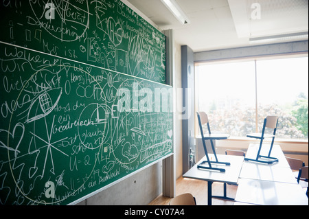Classroom of a grammar school with a blackboard covered with writing Stock Photo