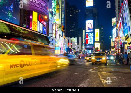 Taxi with motion blur in Times Square, night scene, Manhattan, New York, USA Stock Photo