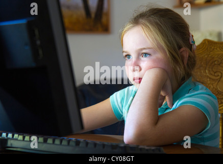 A second-grade American student doing homework at computer. Stock Photo