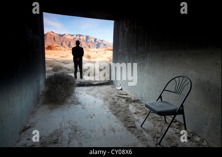Silhouette of male figure standing in tunnel in desert