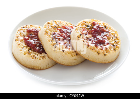 three english crumpets with butter and jam isolated on a white background