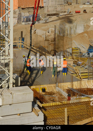 Large construction site, workers pouring concrete into an area surrounded by boarding and reinforcements, North Rhine-Westphalia Stock Photo