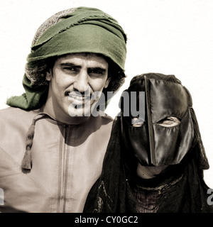 Bedouin Man In Green Turban And Masked Woman In Black, Sinaw, Oman Stock Photo