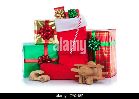 Photo of a red Christmas stocking with gift wrapped presents and toys, isolated on a white background. Stock Photo