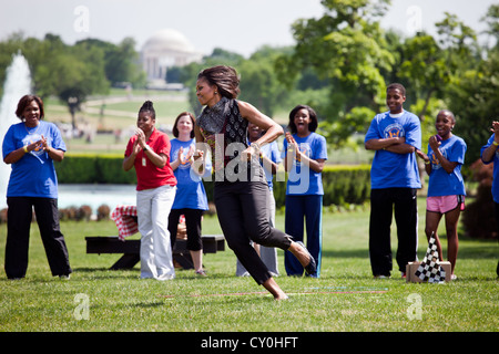 First Lady Michelle Obama participates in the ÒPit Crew ChallengeÓ during an event with the President's Council on Fitness, Sports and Nutrition May 9, 2011 on the South Lawn of the White House. The First Lady visited seven activity stations during the event which helped promote both the Let's Move! and Joining Forces initiatives. Stock Photo