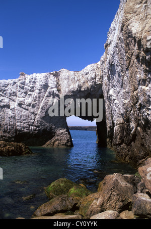 Bwa Gwyn white natural rock sea arch on coast near Rhoscolyn Holy Island Ynys Gybi Isle of Anglesey North Wales UK Stock Photo