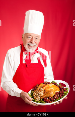 Chef holding a Thanksgiving or Christmas turkey stuffed on a platter.  Stock Photo