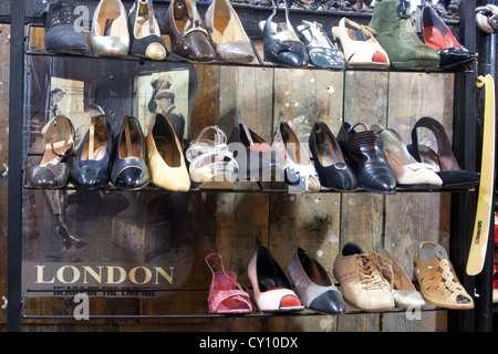 Vintage second hand shoe stall with 'London Heart of the Empire' sign in Camden Stables Market Camden North London England UK Stock Photo