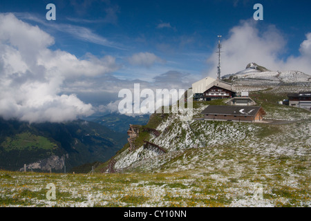 Männlichen cable car station and mountain summit in light dusting of summer snow Bernese Oberland Switzerland Stock Photo