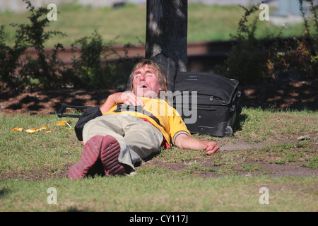 Homeless man sleeping in a park bench Stock Photo - Alamy