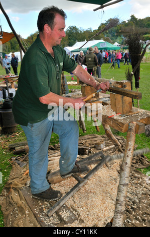 Man demonstrating  Pole Lathe Turning on a treadle lathe ,making brush handles at the Autumn Countryside Show, West Sussex, England, UK Stock Photo