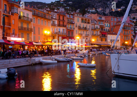 People dining at quayside restaurants at twilight Villefranche-sur-Mer Côte d'Azur Alpes-Maritimes France Stock Photo