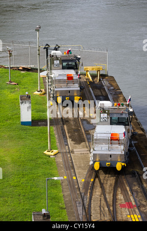 Panama Panama Canal Two electric mules at the end of the track wait to assist ships through the locks Stock Photo