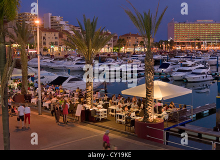 Portugal, the Algarve, Vilamoura marina restaurant on the promenade at dusk Stock Photo