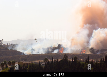 Rescue helicopter helping to extinguish wildfire. Mijas Costa, Malaga, Costa del Sol, Andalucia, Spain. Stock Photo