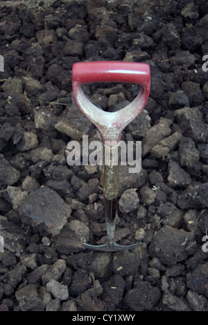 Spade dug into soil on allotment Stock Photo