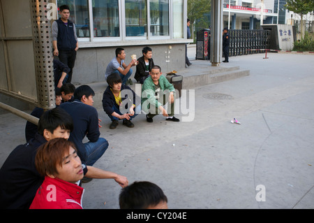 Foxconn workers have a break outside one of its factory gates in Taiyuan, Shannxi province, China. 03-Oct-2012 Stock Photo