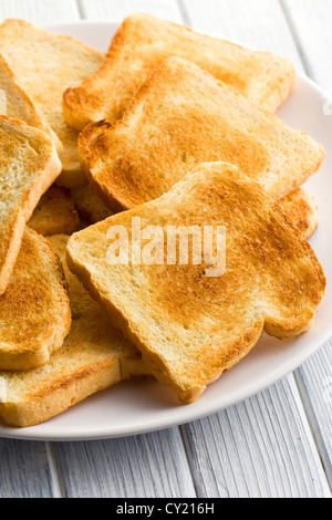 Plate with toasted bread on white background Stock Photo - Alamy