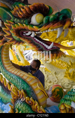 An artist spraypaints an ornamental dragon in Ubud, Bali, Indonesia