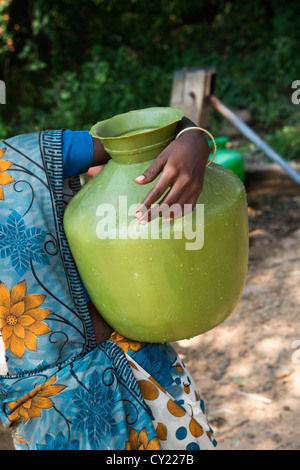 Rural Indian village woman collecting water from a communal water pump. Andhra Pradesh, India Stock Photo