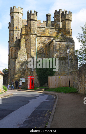 Side view of Battle Abbey Gatehouse with traditional red British telephone box, East Susse, England, UK, GB Stock Photo